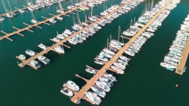Kenetlenmiş yelkenlilerin hava görüntüsü. Limanda demirlemiş beyaz tekne ve yatların en üst görüntüsü. Limanda bir tekne. Tekneli liman. 