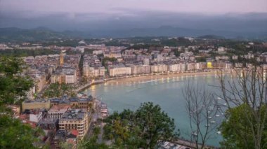 San Sebastian şehrinin, Bask ülkesinin, İspanya 'nın gündüz ve gece geçişi. Kuzey İspanya 'da popüler bir yaz gezisi merkezi olan Donostia' nın gece aydınlanması