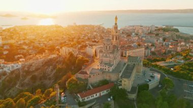 Notre Dame de la Garde 'ın ya da güney Fransa' da günbatımında Muhafız Kilisesi 'nin hava manzarası. Sıcak yaz akşamı ışığı Marsilya şehir manzarasını aydınlatıyor.. 