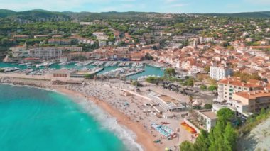 Fransa 'nın güneyindeki Fransız Rivierası' nda Cassis 'in hava görüntüsü. Sahnede uçuruma konmuş bir ortaçağ kalesi, kumlu bir plaj, turkuaz deniz suları ve kasabanın tarihi binaları yer alıyor.