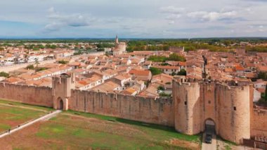 Güneşli bir günde, Fransa 'nın güneyindeki Camargue bölgesinde, pembe tuz gölü yakınlarındaki ortaçağ duvarlı Aigues-Mortes kasabasının havadan görünüşü. 