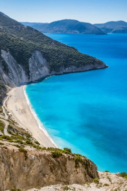 Yunanistan 'ın İyon Denizi' ndeki Kefalonia Adası 'nda güneşli bir yaz gününde güzel Myrtos plajı. Güzel bir turkuaz denizin kıyısındaki Idyllic beyaz kumlu plajı. 