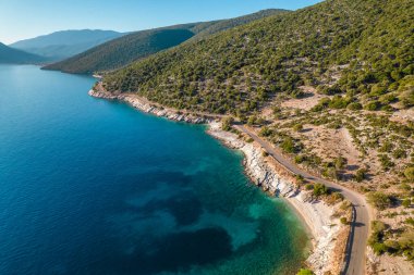 Yunanistan 'ın Kefalonia Adası' ndaki çarpıcı İyon Denizi kıyılarının havadan görünüşü. Kristal berraklığında turkuaz sular Sefalonya adasının vahşi, engebeli kıyıları yakınında.