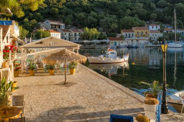 Ithaca Adası, Kefalonia, İyon Denizi, Yunanistan 'daki Kioni köyünde balıkçı teknesi. Gündoğumunda Ihaki tatil köyünün Idyllic manzarası. Tipik Yunan manzarası.