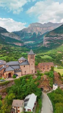 İspanyol Pirenesi dağlarındaki Torla-Ordesa köyü ve Ordesa-Monte Perdido Ulusal Parkı 'nın hava manzarası. Torla-Ordesa 'daki Ortaçağ binaları ve San Salvador Kilisesi, Huesca, İspanya.