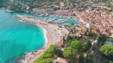 Fransa 'nın güneyindeki Fransız Rivierası' nda Cassis 'in hava görüntüsü. Sahnede uçuruma konmuş bir ortaçağ kalesi, kumlu bir plaj, turkuaz deniz suları ve kasabanın tarihi binaları yer alıyor.