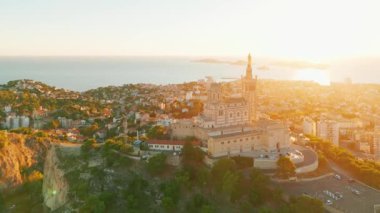 Notre Dame de la Garde 'ın ya da güney Fransa' da günbatımında Muhafız Kilisesi 'nin hava manzarası. Sıcak yaz akşamı ışığı Marsilya şehir manzarasını aydınlatıyor.. 