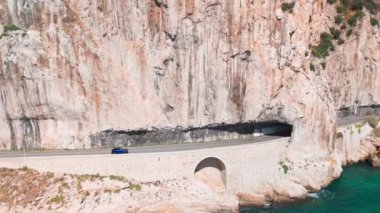 Nice ve Monako arasındaki Fransız Riviera kıyı şeridi havadan görünüyor. Bir araba Corniche Inferieure yolu boyunca Akdeniz 'in turkuaz sularının üzerindeki yüksek uçurumlardan geçiyor.