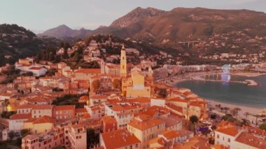 Fransız Rivierası, Fransa 'da Menton' un hava görüntüsü. Muhteşem bir günbatımı, renkli eski kasabanın üzerine sıcak bir ışık saçıyor. Alacakaranlıkta tarihi binalar, plaj ve şehir ışıkları. Fransız Cote dAzur