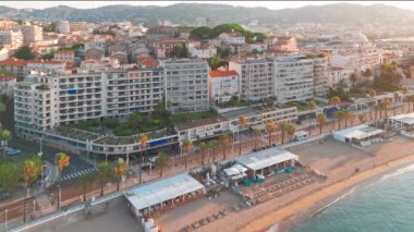 Gündoğumunda Cannes 'da lüks oteller ve konut binaları olan güzel plajın havadan görüntüsü. Yaz boyunca muhteşem Cote dAzur kıyıları