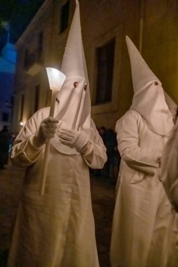 Verges, Spain - March 29: Holy Week or Semana Santa in Verges, Girona province, Catalonia, Spain. Traditional procession with costumes and candles.  clipart