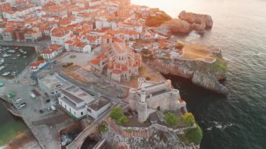 İspanya 'nın kuzeyinde Cantabria' da gün batımında Biscay Körfezi 'nde bulunan pitoresk bir liman şehri olan Castro Urdiales' in hava manzarası. Santa Maria de la Asuncion Kilisesi ve Santa Ana Şatosu Deniz feneri.