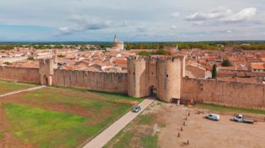 Güneşli bir günde, Fransa 'nın güneyindeki Camargue bölgesinde, pembe tuz gölü yakınlarındaki ortaçağ duvarlı Aigues-Mortes kasabasının havadan görünüşü. 
