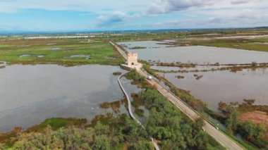 Fransa 'nın güneyindeki Aigues-Mortes yakınlarındaki Saint-Laurent-dAigouze, Petite Camargue' de Tour Carbonniere 'in hava manzarası. Ortaçağ kulesi manzaralı bataklıklarla çevrili.