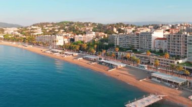 Aerial view of the beautiful beach in Cannes at sunrise, with luxury hotels and residential buildings. The magnificent Cote dAzur coast during summer