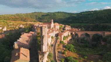 Fransa 'nın güneyindeki Minerve Ortaçağ köyünün havadan görünüşü. Tarihi taş binalar, güzel kemerli bir köprü ve gökyüzünde renkli bir gökkuşağı..