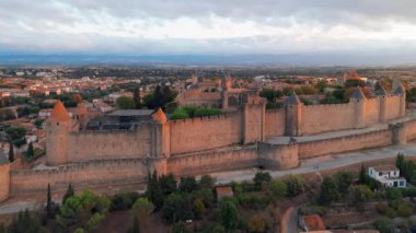 Ortaçağ şehri Carcassonne 'un havadan görünüşü ve güney Fransa' daki gündoğumunda bulunan kale. Güzel sabah aydınlığında ikonik ortaçağ kuleleriyle ünlü tarihi kale.