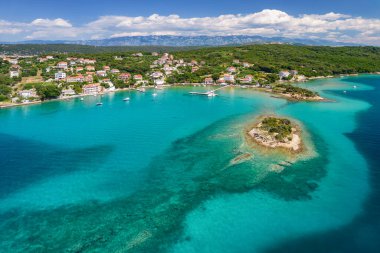 Hırvatistan 'ın Rab adasındaki Gonar sahilinin inanılmaz berrak deniz suyu. Hırvatistan 'ın Dalmaçya bölgesinde cennet turkuvaz deniz suyuyla Rab Adası' nın güzel sahil manzarası.