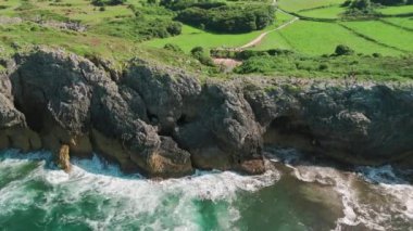 İspanya 'nın kuzeyinde, Asturias' taki Gulpiyuri plajı. Eşsiz Playa de Gulpiyuri 'nin havadan görünüşü denizden ayrılmış ve yemyeşil çayırlarla çevrili gizli bir lagün..