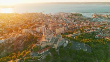 Notre Dame de la Garde 'ın ya da güney Fransa' da günbatımında Muhafız Kilisesi 'nin hava manzarası. Sıcak yaz akşamı ışığı Marsilya şehir manzarasını aydınlatıyor.. 