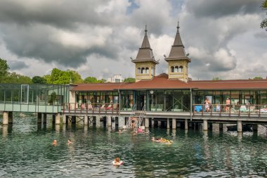 Heviz, Macaristan - 6 Ağustos 2023: Kimliği belirsiz insanlar Macaristan 'daki ünlü Heviz termal gölünde yüzüyorlar. Termal suyu olan güzel bir göl. Macaristan 'da popüler tatil beldesi.