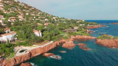 Günbatımında Fransız Riviera 'sı Provence-Alpes-Cote dAzur, Fransa' da Esterel Massif 'in ikonik kırmızı kayaları ile Antheor köyünün hava manzarası. Cote dAzur 'daki lüks villalar..