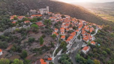 Gündoğumunda Fransa 'nın en güzel köylerinden biri olan ve popüler bir turizm beldesi olan Pirenes dağlarındaki ortaçağ tepe kasabası Eus' un hava manzarası.