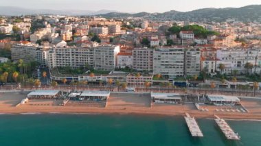 Gündoğumunda Cannes 'da lüks oteller ve konut binaları olan güzel plajın havadan görüntüsü. Yaz boyunca muhteşem Cote dAzur kıyıları