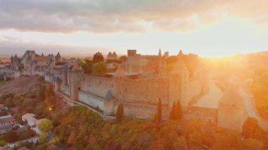 Ortaçağ şehri Carcassonne 'un havadan görünüşü ve güney Fransa' daki gündoğumunda bulunan kale. Güzel sabah aydınlığında ikonik ortaçağ kuleleriyle ünlü tarihi kale.