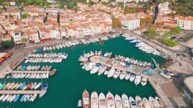 Fransa 'nın güneyindeki Fransız Rivierası' nda Cassis 'in hava görüntüsü. Sahnede uçuruma konmuş bir ortaçağ kalesi, kumlu bir plaj, turkuaz deniz suları ve kasabanın tarihi binaları yer alıyor.