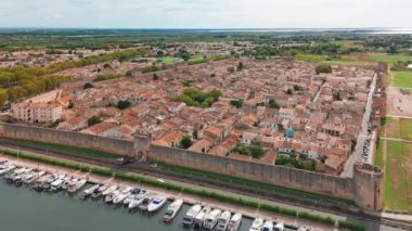 Güneşli bir günde, Fransa 'nın güneyindeki Camargue bölgesinde, pembe tuz gölü yakınlarındaki ortaçağ duvarlı Aigues-Mortes kasabasının havadan görünüşü. 