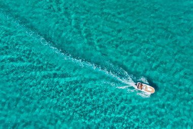 İspanya 'nın Balear Adaları, Mallorca' daki çarpıcı Akdeniz kıyılarının hava manzarası. Mallorca adasının turkuaz sularında yüzen küçük bir tekne..