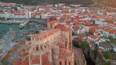 İspanya 'nın kuzeyinde Cantabria' da gün batımında Biscay Körfezi 'nde bulunan pitoresk bir liman şehri olan Castro Urdiales' in hava manzarası. Santa Maria de la Asuncion Kilisesi ve Santa Ana Şatosu Deniz feneri.