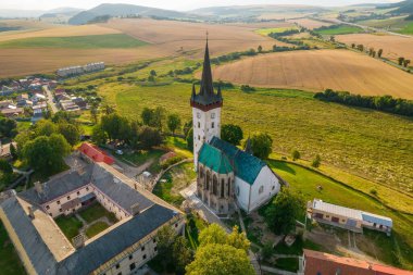 Slovakya 'nın Spissky Stvrtok kasabasındaki eski kilise. Tarihi bir kilise ve yaz boyunca Slovakya 'da küçük bir köy ile geleneksel kırsal manzaranın güzel hava manzarası.