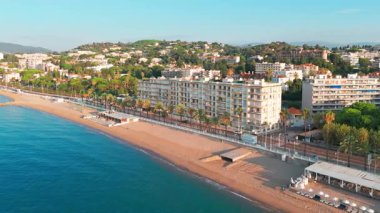 Gündoğumunda Cannes 'da lüks oteller ve konut binaları olan güzel plajın havadan görüntüsü. Yaz boyunca muhteşem Cote dAzur kıyıları