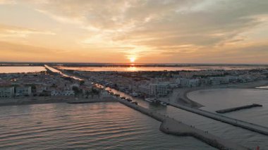 Fransa 'nın Occitanie bölgesindeki bir tatil beldesi olan Camargue' deki Grau du Roi balıkçı köyünün gündoğumunda hava manzarası. Güney Fransa 'daki güzel sahil kasabası Grau du Roi