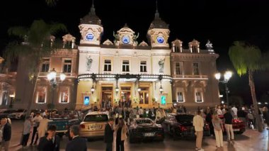 Monte Carlo, Monaco - 28 Eylül 2024: gece ünlü Monte-Carlo kumarhanesi. Fransız Rivierası 'ndaki tarihi kumarhanenin önündeki lüks süper arabalar. Monako Prensliğinin Şehir Merkezi