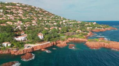 Günbatımında Fransız Riviera 'sı Provence-Alpes-Cote dAzur, Fransa' da Esterel Massif 'in ikonik kırmızı kayaları ile Antheor köyünün hava manzarası. Cote dAzur 'daki lüks villalar..