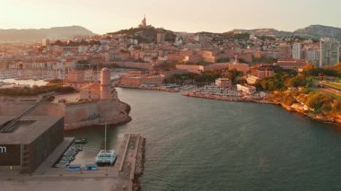 Güney Fransa 'da gün doğumunda Marsilya şehir manzarası. Marsilya 'da güzel bir yaz sabahı. Tarihi Vieux Limanı, Saint-Jean Kalesi ve Basilique Notre-Dame de la Garde