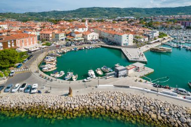 Slovenya 'nın Istria bölgesindeki Adriyatik deniz kıyısındaki Picturesque Izola kasabası. Hava aracı görüntüsü. Küçük marina, ortaçağ binaları ve eski kilise..