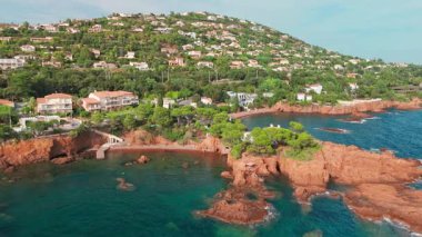 Günbatımında Fransız Riviera 'sı Provence-Alpes-Cote dAzur, Fransa' da Esterel Massif 'in ikonik kırmızı kayaları ile Antheor köyünün hava manzarası. Cote dAzur 'daki lüks villalar..