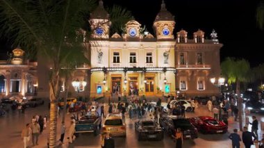 Monte Carlo, Monaco - 28 Eylül 2024: gece ünlü Monte-Carlo kumarhanesi. Fransız Rivierası 'ndaki tarihi kumarhanenin önündeki lüks süper arabalar. Monako Prensliğinin Şehir Merkezi