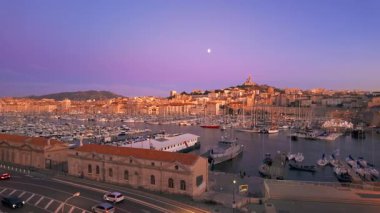 Geceleri Marsilya şehrinin silueti yavaş dönüyor, Fransa. Marsilya 'nın güzel manzarası. Tarihi Vieux Limanı, Basilique Notre-Dame de la Garde, Fransız Rivierası.