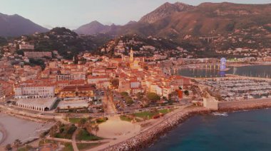 Fransız Rivierası, Fransa 'da Menton' un hava görüntüsü. Muhteşem bir günbatımı, renkli eski kasabanın üzerine sıcak bir ışık saçıyor. Alacakaranlıkta tarihi binalar, plaj ve şehir ışıkları. Fransız Cote dAzur