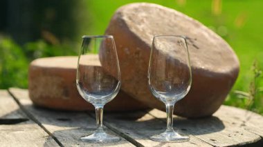 Arka planda lezzetli Ossau-Iraty peyniri tekerlekleri olan iki bardağa beyaz şarap doldurmak. Ossau-Iraty koyun sütünden yapılmış bir Bask peyniri.. 