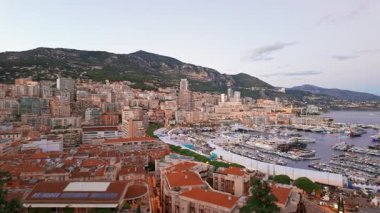 Alacakaranlıktaki Monako şehrinin göz alıcı panoramik manzarası. Gökdelenler ve lüks yatlar, Herkül Limanı 'nı oluşturur. Fransız Rivierası 'nda Monte Carlo' nun tarihi mimarisi. 