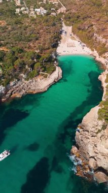 İspanya 'nın Balearic Adaları, Mallorca' daki Cala Llombards plajının yukarıdan görünüşü. Turkuaz su limanı ve beyaz kumsal sahili ile Akdeniz kıyılarını sersemletiyor. Mallorca seyahat noktaları