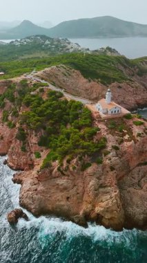 İspanya, Balearic Adaları, Mallorca 'daki Faro Capdepera deniz fenerinin hava manzarası. Manzaralı deniz feneri, Mayorka adasındaki Akdeniz manzaralı yüksek bir uçuruma tünemişti..