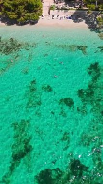Playa de Formentor 'un Mallorca' daki Cala Pi de la Posada körfezindeki hava manzarası. Cap Formentor, Mayorka, Balear Adaları, İspanya 'da turkuaz sularda yüzen insanların olduğu çarpıcı bir sahil..