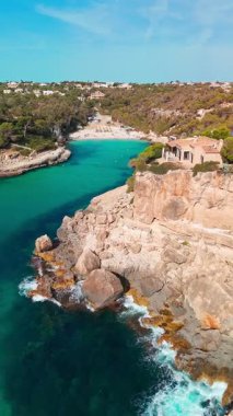 İspanya 'nın Balearic Adaları, Mallorca' daki Cala Llombards plajının yukarıdan görünüşü. Turkuaz su limanı ve beyaz kumsal sahili ile Akdeniz kıyılarını sersemletiyor. Mallorca seyahat noktaları